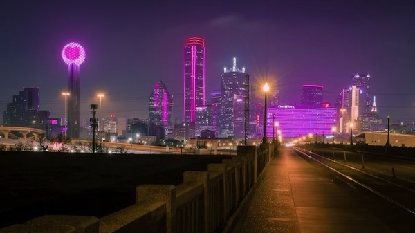 A beautiful image of the Downtown Dallas Skyline at night showing off the buildings bright neon pink colors.