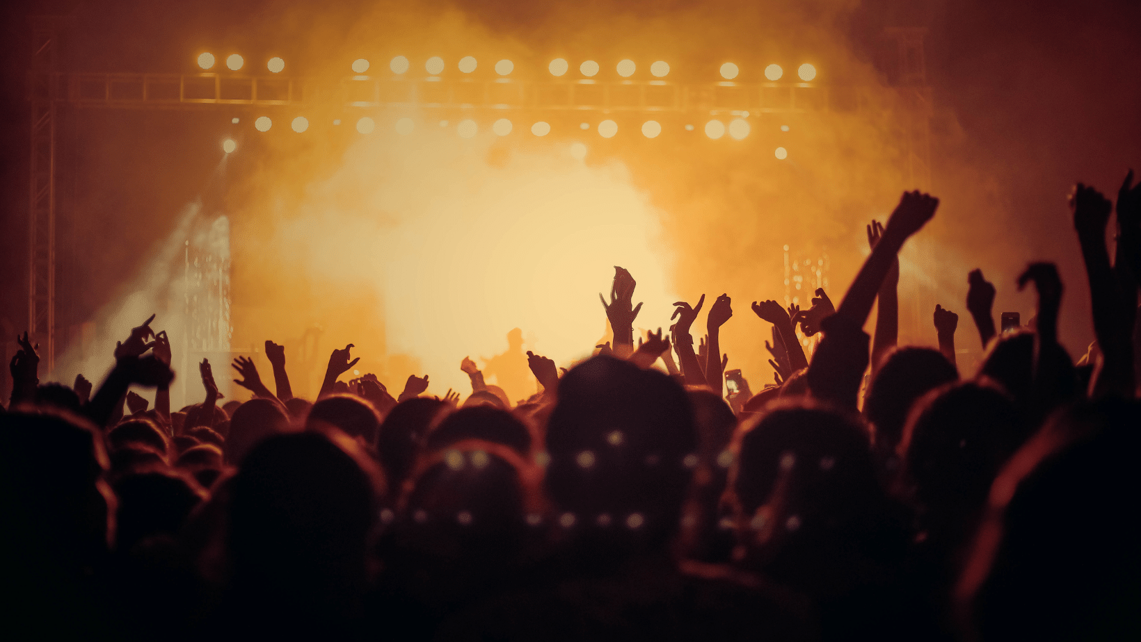 A crowd of people at a concert with their hands in the air, symbolizes event geo-fence marketing.