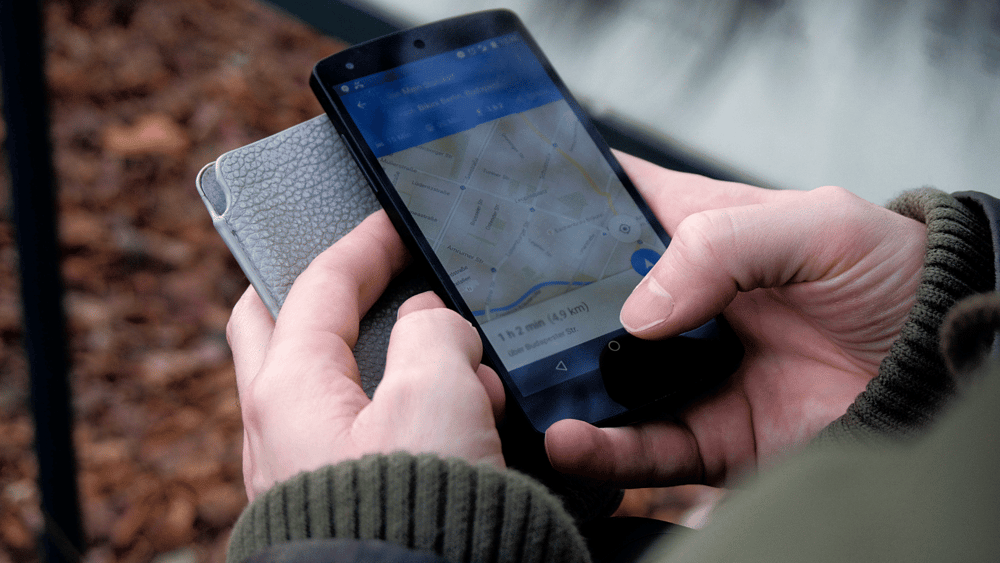 Ascend Adwerks' image of a person holding a cell phone with a map on it, symbolizing geo-fencing.