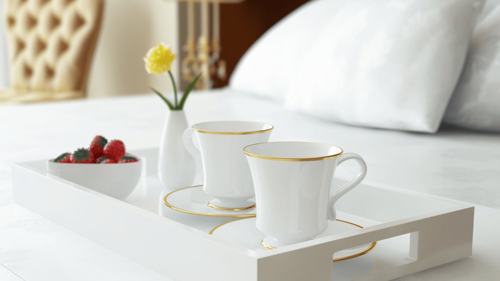 A tray with two cups of coffee and a bowl of strawberries on a bed symbolizes hospitality marketing services.