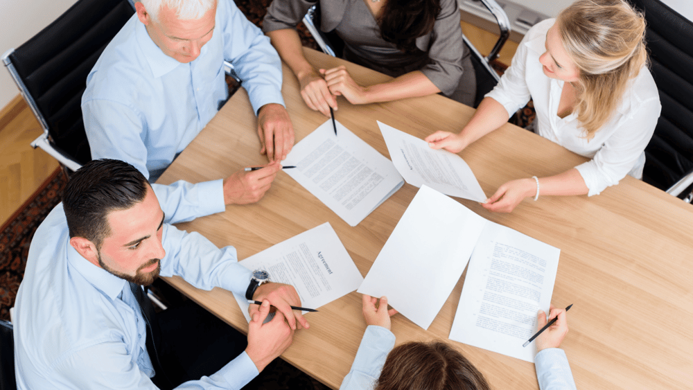 A professional law firm team sitting around a table discussing Ascend Adwerks digital marketing services.
