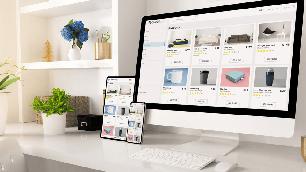 A desktop computer, laptop and phone sitting on a desk with products from an e-commerce website on display.
